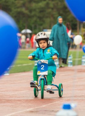 Kazakistan, Almaty - 11 Haziran 2017: yarışmalar Bisiklete binme çocuk de çocuklar tur. 2 ile 7 yaş arası çocuklar stadyumda rekabet ve ödüller alırsınız. Küçük bir çocuk bisiklet sürmek ve olmak için yarışıyor
