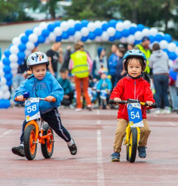 Kazakistan, Almaty - 11 Haziran 2017: yarışmalar Bisiklete binme çocuk de çocuklar tur. 2 ile 7 yaş arası çocuklar stadyumda rekabet ve ödüller alırsınız. Bir spor stadyum üzerinde kız bir bisiklet sürmek