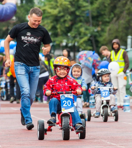 KAZAKHSTAN, ALMATY - JUNE 11, 2017: Childrens cycling competitions Tour de kids. Children aged 2 to 7 years compete in the stadium and receive prizes. A little boy rides a bike and competes to become — Stock Photo, Image