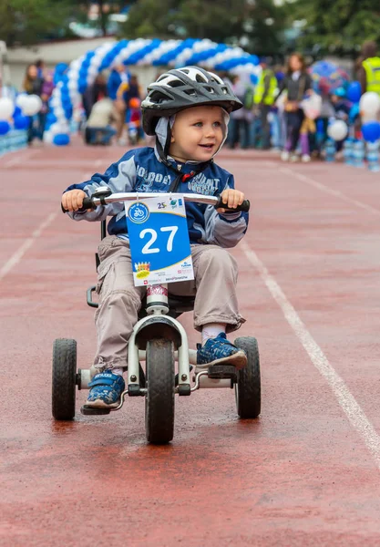 Kazachstan, Almaty - 11 czerwca 2017 r.: Dla dzieci zawody rowerowe Tour de dzieci. Dzieci w wieku od 2 do 7 lat konkurować na stadionie i otrzymać nagrody. Mały chłopiec jeździ rowerem i konkuruje się — Zdjęcie stockowe