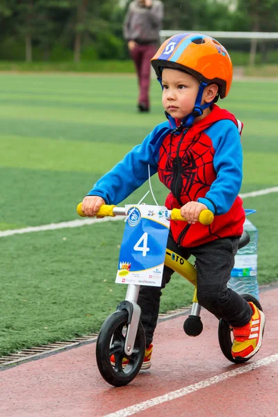 Kazachstan, Alma-Ata - 11 juni 2017: Childrens wedstrijden fietsen Tour de kinderen. Kinderen van 2 tot en met 7 jaar oud concurreren in het stadion en prijzen ontvangen. Een kleine jongen een fiets rijdt en concurreert om te worden — Stockfoto