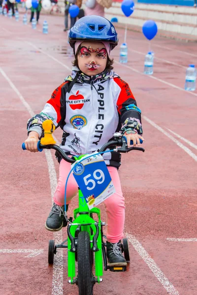 Kazachstan, Alma-Ata - 11 juni 2017: Childrens wedstrijden fietsen Tour de kinderen. Kinderen van 2 tot en met 7 jaar oud concurreren in het stadion en prijzen ontvangen. Het meisje op een fiets rijdt op een sportstadion — Stockfoto