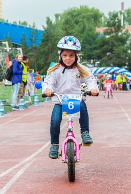 Kazakistan, Almaty - 11 Haziran 2017: yarışmalar Bisiklete binme çocuk de çocuklar tur. 2 ile 7 yaş arası çocuklar stadyumda rekabet ve ödüller alırsınız. Bir spor stadyum üzerinde kız bir bisiklet sürmek