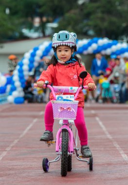 Kazakistan, Almaty - 11 Haziran 2017: yarışmalar Bisiklete binme çocuk de çocuklar tur. 2 ile 7 yaş arası çocuklar stadyumda rekabet ve ödüller alırsınız. Bir spor stadyum üzerinde kız bir bisiklet sürmek