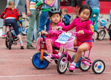Kazakistan, Almaty - 11 Haziran 2017: yarışmalar Bisiklete binme çocuk de çocuklar tur. 2 ile 7 yaş arası çocuklar stadyumda rekabet ve ödüller alırsınız. Bir spor stadyum üzerinde kız bir bisiklet sürmek