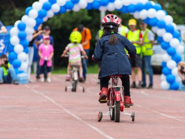 Kazakistan, Almaty - 11 Haziran 2017: yarışmalar Bisiklete binme çocuk de çocuklar tur. 2 ile 7 yaş arası çocuklar stadyumda rekabet ve ödüller alırsınız. Bir spor stadyum üzerinde kız bir bisiklet sürmek