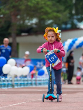 Kazakistan, Almaty - 11 Haziran 2017: yarışmalar Bisiklete binme çocuk de çocuklar tur. 2 ile 7 yaş arası çocuklar stadyumda rekabet ve ödüller alırsınız. Bir spor stadyum üzerinde kız bir bisiklet sürmek