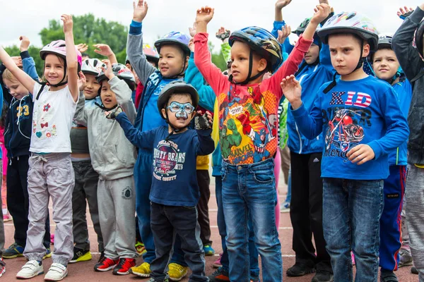 KAZAKHSTAN, ALMATY - 11 de junio de 2017: Concursos de ciclismo infantil Tour de kids. Los niños de 2 a 7 años compiten en el estadio y reciben premios. Niños en la construcción solemne - esperando — Foto de Stock