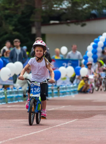 KAZAKHSTAN, ALMATY - JUNE 11, 2017: Childrens cycling competitions Tour de kids. Children aged 2 to 7 years compete in the stadium and receive prizes. The girl on a bicycle rides on a sports stadium — Stock Photo, Image