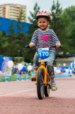 Kazakistan, Almaty - 11 Haziran 2017: yarışmalar Bisiklete binme çocuk de çocuklar tur. 2 ile 7 yaş arası çocuklar stadyumda rekabet ve ödüller alırsınız. Bir spor stadyum üzerinde kız bir bisiklet sürmek