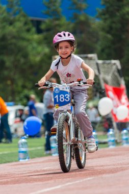 Kazakistan, Almaty - 11 Haziran 2017: yarışmalar Bisiklete binme çocuk de çocuklar tur. 2 ile 7 yaş arası çocuklar stadyumda rekabet ve ödüller alırsınız. Bir spor stadyum üzerinde kız bir bisiklet sürmek