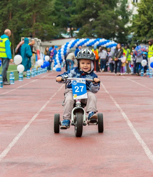 KAZAKHSTAN, ALMATY - JUNE 11, 2017: Childrens cycling competitions Tour de kids. Children aged 2 to 7 years compete in the stadium and receive prizes. A little boy rides a bike and competes to become — Stock Photo, Image