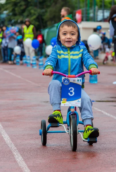 Kazachstan, Alma-Ata - 11 juni 2017: Childrens wedstrijden fietsen Tour de kinderen. Kinderen van 2 tot en met 7 jaar oud concurreren in het stadion en prijzen ontvangen. Een kleine jongen een fiets rijdt en concurreert om te worden — Stockfoto