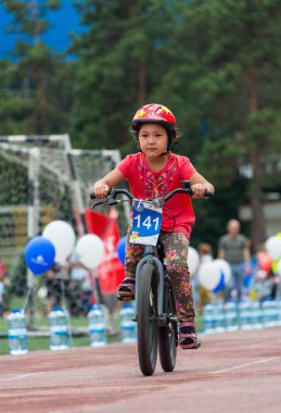 Kazakistan, Almaty - 11 Haziran 2017: yarışmalar Bisiklete binme çocuk de çocuklar tur. 2 ile 7 yaş arası çocuklar stadyumda rekabet ve ödüller alırsınız. Bir spor stadyum üzerinde kız bir bisiklet sürmek