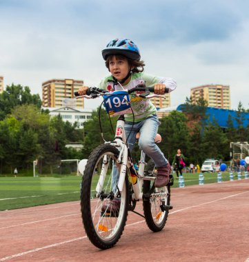 Kazakistan, Almaty - 11 Haziran 2017: yarışmalar Bisiklete binme çocuk de çocuklar tur. 2 ile 7 yaş arası çocuklar stadyumda rekabet ve ödüller alırsınız. Bir spor stadyum üzerinde kız bir bisiklet sürmek