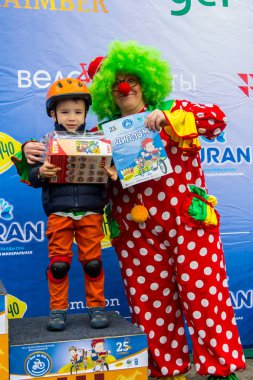 Kazakistan, Almaty - 11 Haziran 2017: yarışmalar Bisiklete binme çocuk de çocuklar tur. 2 ile 7 yaş arası çocuklar stadyumda rekabet ve ödüller alırsınız. Küçük kız ve palyaço avuç içi oynamak.