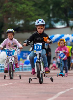 Kazakistan, Almaty - 11 Haziran 2017: yarışmalar Bisiklete binme çocuk de çocuklar tur. 2 ile 7 yaş arası çocuklar stadyumda rekabet ve ödüller alırsınız. Bir spor stadyum üzerinde kız bir bisiklet sürmek