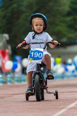 Kazakistan, Almaty - 11 Haziran 2017: yarışmalar Bisiklete binme çocuk de çocuklar tur. 2 ile 7 yaş arası çocuklar stadyumda rekabet ve ödüller alırsınız. Bisiklet üzerinde şirin bir çocuk portresi
