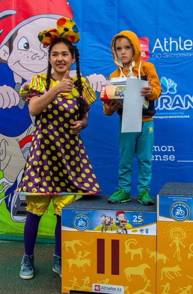 カザフスタン、アルマトイ国際空港-2017 年 6 月 11 日: 子供競技大会ツアー ・ デ ・子供です。2 に 7 歳のお子様は、競技場で競うし、賞品を受け取る。少女とピエロ プレイ ヤシの木. — ストック写真