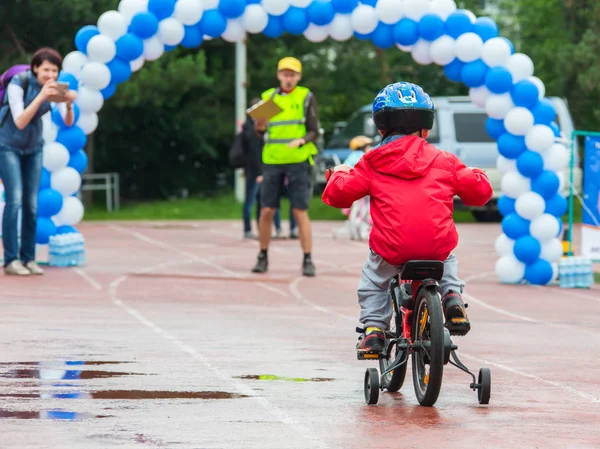Kazachstan, Almaty - 11 czerwca 2017 r.: Dla dzieci zawody rowerowe Tour de dzieci. Dzieci w wieku od 2 do 7 lat konkurować na stadionie i otrzymać nagrody. Mały chłopiec jeździ trójkołowy na drodze — Zdjęcie stockowe