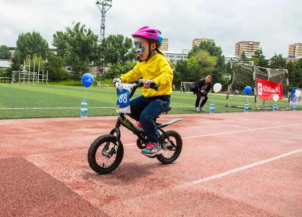 KAZAKHSTAN, ALMATY - 11 de junio de 2017: Concursos de ciclismo infantil Tour de kids. Los niños de 2 a 7 años compiten en el estadio y reciben premios. Retrato de un lindo chico en bicicleta — Foto de Stock