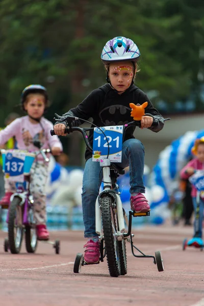 Kazachstan, Alma-Ata - 11 juni 2017: Childrens wedstrijden fietsen Tour de kinderen. Kinderen van 2 tot en met 7 jaar oud concurreren in het stadion en prijzen ontvangen. Het meisje op een fiets rijdt op een sportstadion — Stockfoto