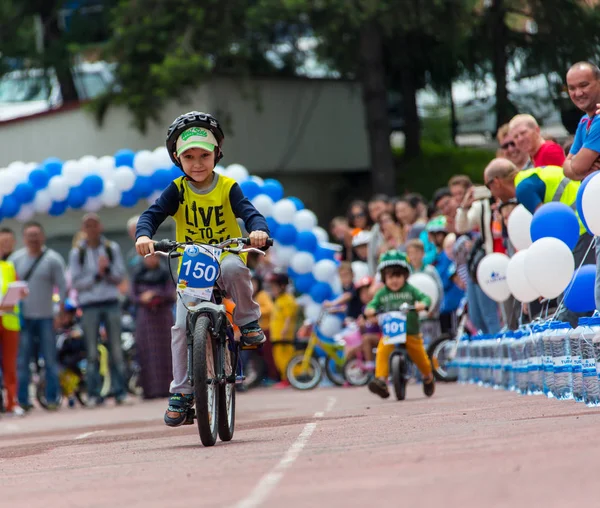 KAZAKHSTAN, ALMATY - 11 de junio de 2017: Concursos de ciclismo infantil Tour de kids. Los niños de 2 a 7 años compiten en el estadio y reciben premios. Retrato de un lindo chico en bicicleta — Foto de Stock