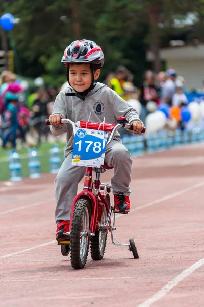 Kazakistan, Almaty - 11 Haziran 2017: yarışmalar Bisiklete binme çocuk de çocuklar tur. 2 ile 7 yaş arası çocuklar stadyumda rekabet ve ödüller alırsınız. Bisiklet üzerinde şirin bir çocuk portresi — Stok fotoğraf