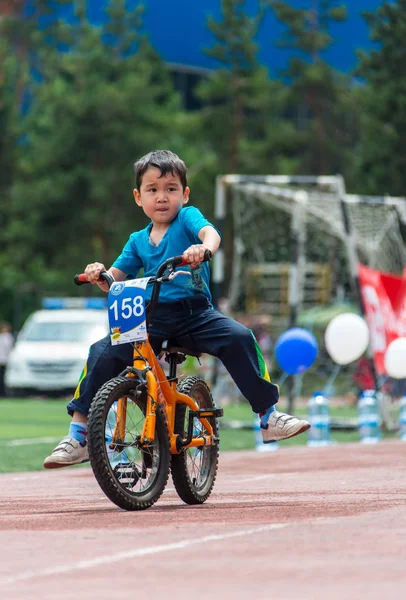 Kazakistan, Almaty - 11 Haziran 2017: yarışmalar Bisiklete binme çocuk de çocuklar tur. 2 ile 7 yaş arası çocuklar stadyumda rekabet ve ödüller alırsınız. Bisiklet üzerinde şirin bir çocuk portresi — Stok fotoğraf