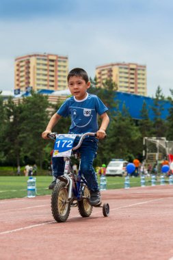 Kazakistan, Almaty - 11 Haziran 2017: yarışmalar Bisiklete binme çocuk de çocuklar tur. 2 ile 7 yaş arası çocuklar stadyumda rekabet ve ödüller alırsınız. Bisiklet üzerinde şirin bir çocuk portresi