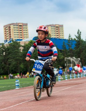 Kazakistan, Almaty - 11 Haziran 2017: yarışmalar Bisiklete binme çocuk de çocuklar tur. 2 ile 7 yaş arası çocuklar stadyumda rekabet ve ödüller alırsınız. Bisiklet üzerinde şirin bir çocuk portresi