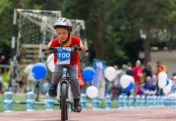 KAZAKHSTAN, ALMATY - 11 de junio de 2017: Concursos de ciclismo infantil Tour de kids. Los niños de 2 a 7 años compiten en el estadio y reciben premios. Retrato de un lindo chico en bicicleta — Foto de Stock