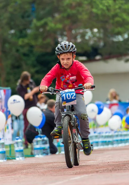 Kazachstan, Alma-Ata - 11 juni 2017: Childrens wedstrijden fietsen Tour de kinderen. Kinderen van 2 tot en met 7 jaar oud concurreren in het stadion en prijzen ontvangen. Portret van een leuke jongen op fiets — Stockfoto