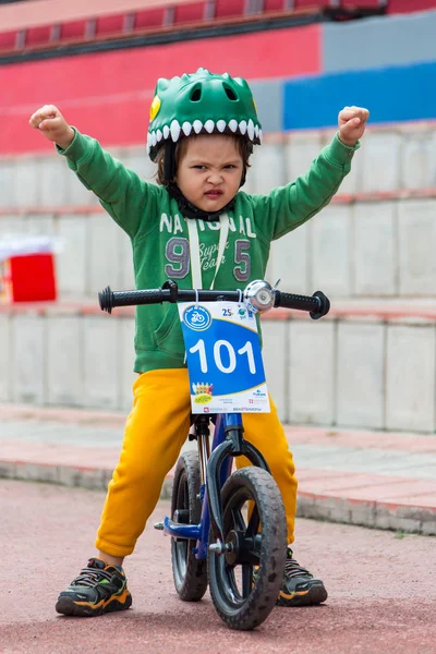 KAZAKHSTAN, ALMATY - JUNE 11, 2017: Childrens cycling competitions Tour de kids. Children aged 2 to 7 years compete in the stadium and receive prizes. Little boy rides a tricycle on the road — Stock Photo, Image