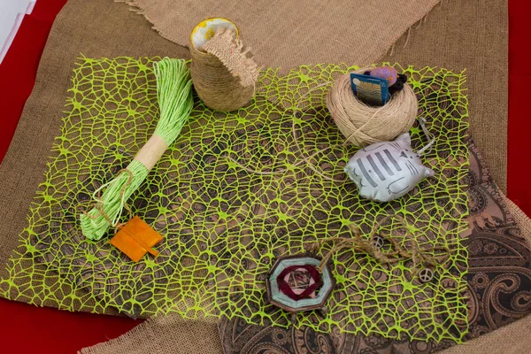 Sewing textile or cloth. Gold scissors pin cushion, and natural white fabric. Work table of a tailor. Shallow depth of field, Focus on scissors — Stock Photo, Image