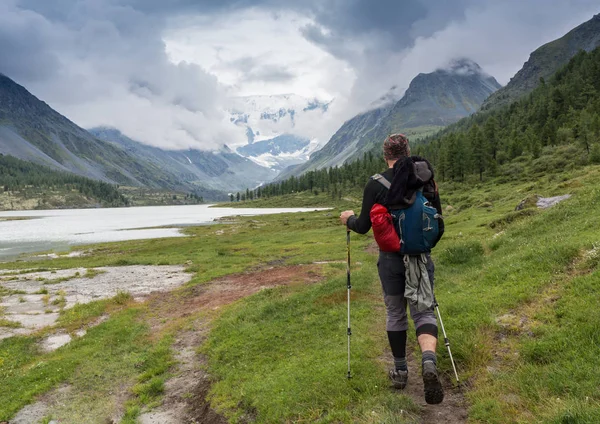 Turista con zaino e panorama montano — Foto Stock