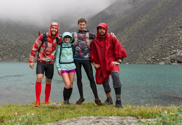 Glückliche Freunde entspannen sich am See. Menschen genießen schönen See und gutes Regenwetter im Altai, Russland — Stockfoto