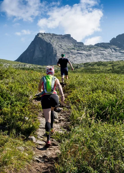 ERGAKI, RUSSIA - AUGUST 05 2017: Several athletes run through the mountains, participants trailing the SKAYRANFEST competition on August 5, 2017 in the Ergaki National Park, Russia. — Stock Photo, Image