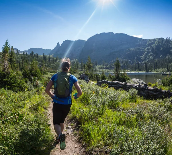 ERGAKI, RUSSIA - 05 AGOSTO 2017: Sconosciuta sportiva che corre tra le montagne, partecipante al concorso di trailrunning SKAYRANFEST 5 agosto 2017 nel parco nazionale di Ergaki, Russia . — Foto Stock