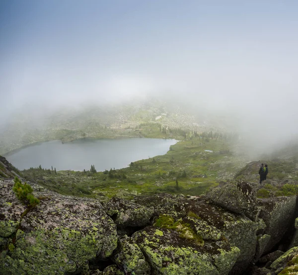 Paar im Nebel auf dem Steg am See an einem Winternachmittag. friedliche Atmosphäre. Nebelluft. — Stockfoto