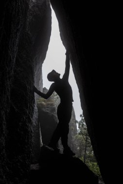 Kaya duvarları arasında duran ve ileri ileri görüşlü kavramı arayan adam.