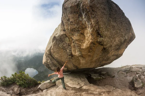 Dağcı bouldering doğada var. Kız büyük bir taş üzerinde tırmanıyor. Kadının açık havada spor yapması. Atlet etkinlik mekanlarda devreye girer. — Stok fotoğraf