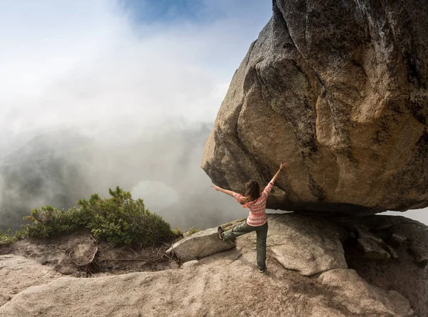 Horolezec je bouldering v přírodě. Dívka se šplhá na velký kámen. Žena, která dělá sportovní venku. Sportovec se zabývá činností venku. — Stock fotografie