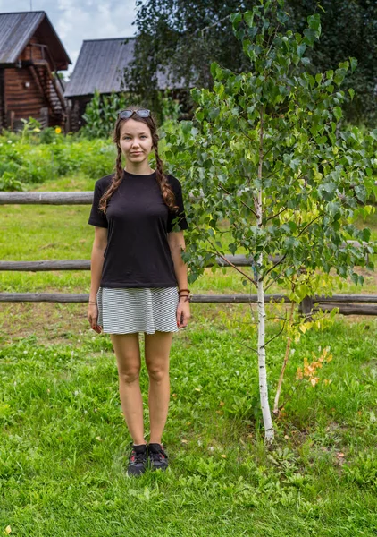 Menina com ancinho de madeira e balde na estrada rural na aldeia. Espaço de cópia — Fotografia de Stock