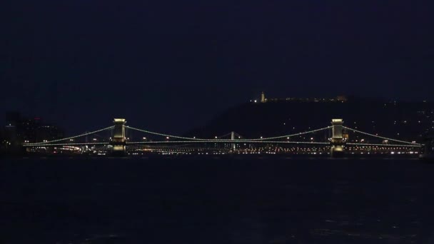 Puente iluminado de Szechenyi y palacio real en la colina de Buda Imágenes de Budapest - Puente de la cadena situado en la capital húngara de Budapest iluminado por la noche — Vídeo de stock