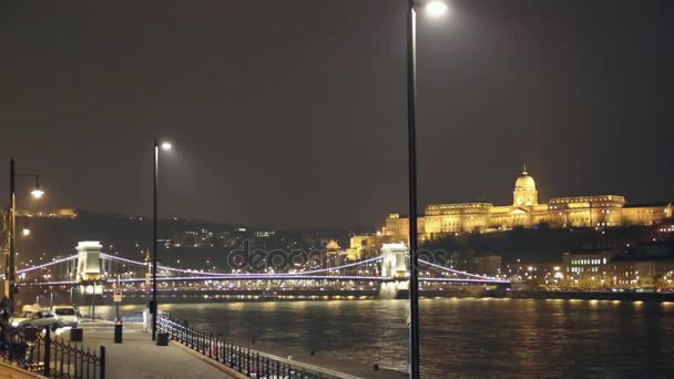 Verlichte Szechenyi-brug en Koninklijke Paleis op Buda heuvel Budapest footage - Chain Bridge ligt in de Hongaarse hoofdstad Boedapest verlicht door de nacht — Stockvideo