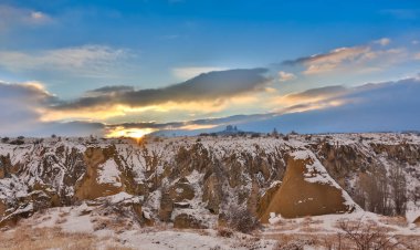 Kapadokya, Orta Anadolu, Türkiye bir dağlardan görünümü bir Uçhisar Kalesi ve eski Uçhisar mağara kasaba kazdık. Kış vakti güneş ile