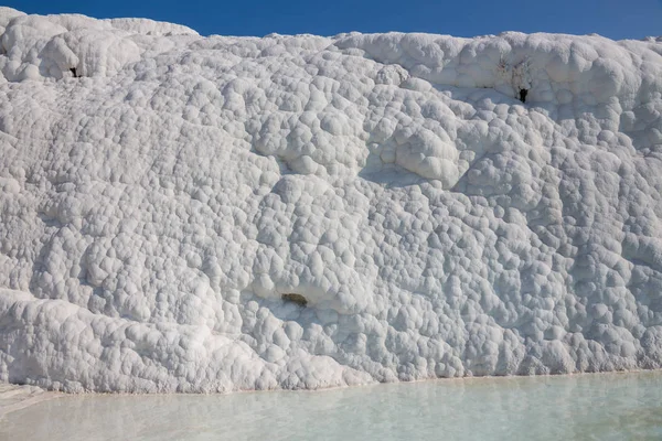 The enchanting pools of Pamukkale in Turkey. Pamukkale contains hot springs and travertines, terraces of carbonate minerals left by the flowing water. The site is a UNESCO World Heritage Site.