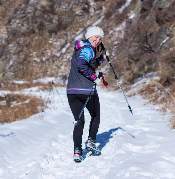 Alma-Ata, Kazachstan--09 April 2017: Amateur competities - berg halve marathon, in de uitlopers van Almaty, op de Yunat-meren. Jonge vrouw joggen buiten in zonnige winter bergen — Stockfoto