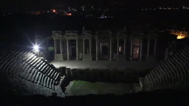 Pequeño anfiteatro en el parque Souq Waqif por la noche hiperlapso timelapse en Doha, con vegetación y edificios en la distancia, incluyendo centro islámico iluminado. — Vídeos de Stock